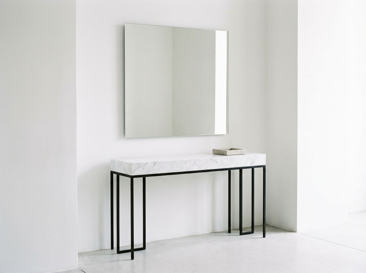 Minimalist bedroom with platform bed, white linen bedding, and single pendant light